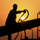 In this file photo taken July 7, 2010, an unidentified oilfield worker ties pipes to be raised on an oil rig as the sun sets in the Persian Gulf desert oil field of Sakhir, Bahrain. Exxon earned the majority of its income from exploration and production operations in foreign waters, particularly in Africa, Asia and the Middle East. Exxon's results showed a jump in profits across its exploration and production, refining and chemicals businesses.